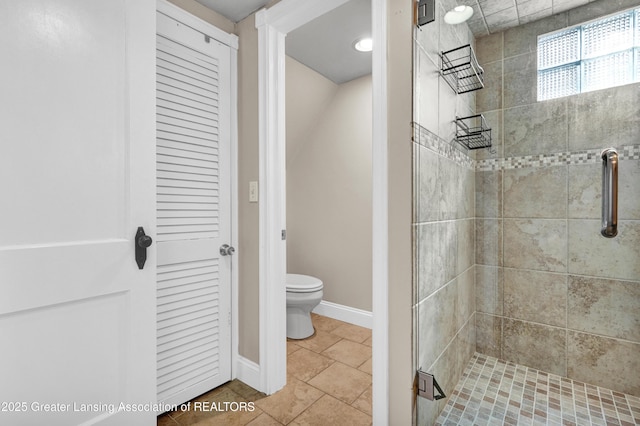 full bath with baseboards, tile patterned flooring, a stall shower, and toilet