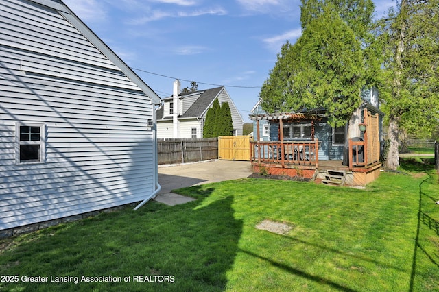 view of yard with fence, a pergola, a patio area, and a wooden deck
