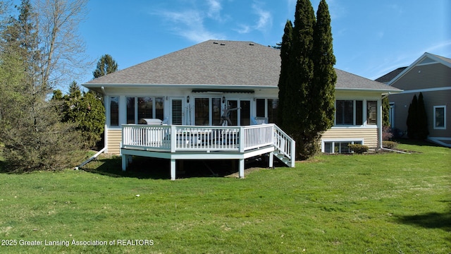 back of house with a lawn, roof with shingles, and a deck