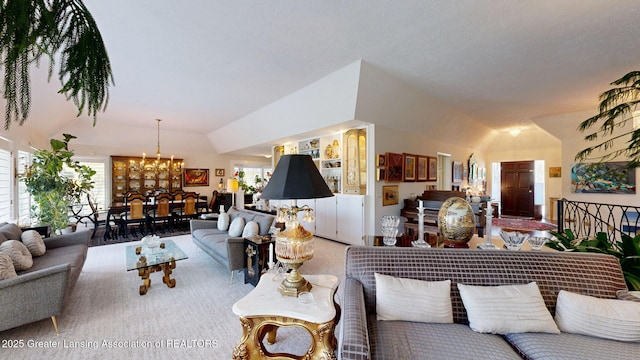living room featuring carpet floors, lofted ceiling, and a notable chandelier