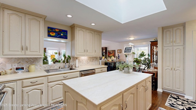 kitchen with cream cabinetry, dark wood finished floors, a sink, and tasteful backsplash