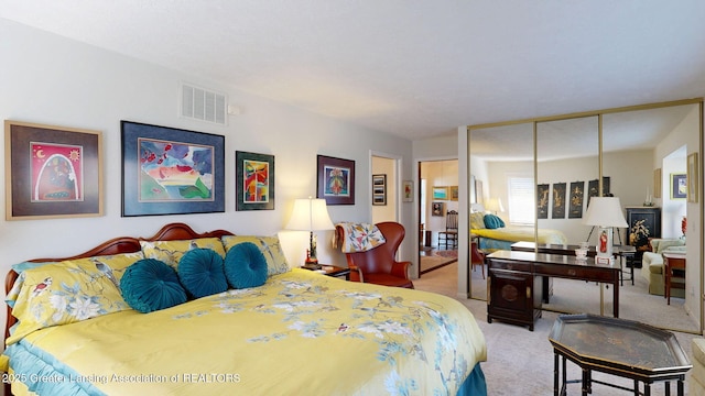 carpeted bedroom with a closet and visible vents