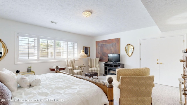 carpeted bedroom with visible vents and a textured ceiling
