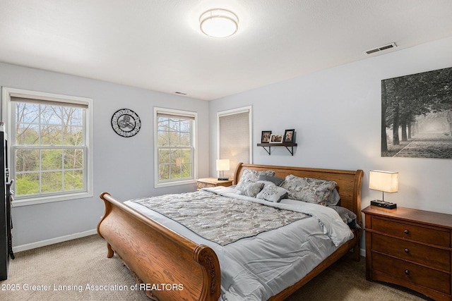 carpeted bedroom featuring baseboards and visible vents