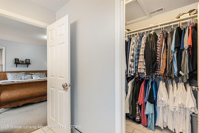 spacious closet with marble finish floor, visible vents, and attic access