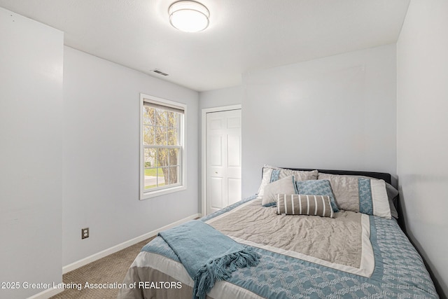 carpeted bedroom with baseboards, visible vents, and a closet