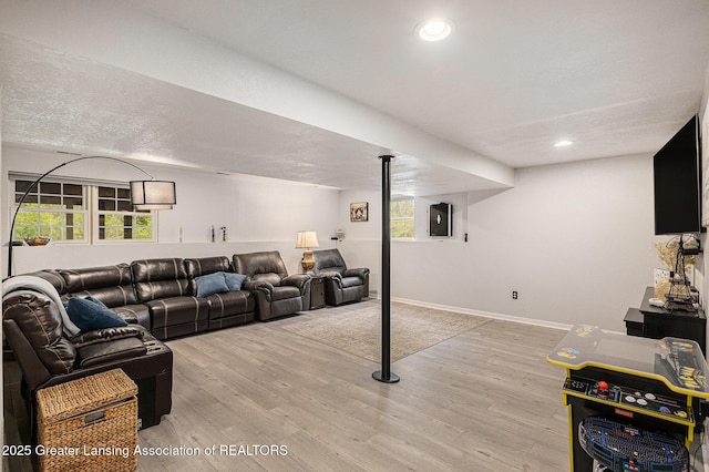 living room with recessed lighting, baseboards, and light wood-type flooring