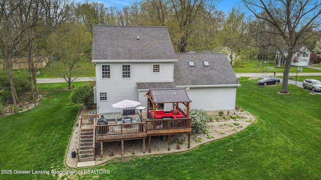 rear view of house featuring a lawn, a deck, stairs, and roof with shingles