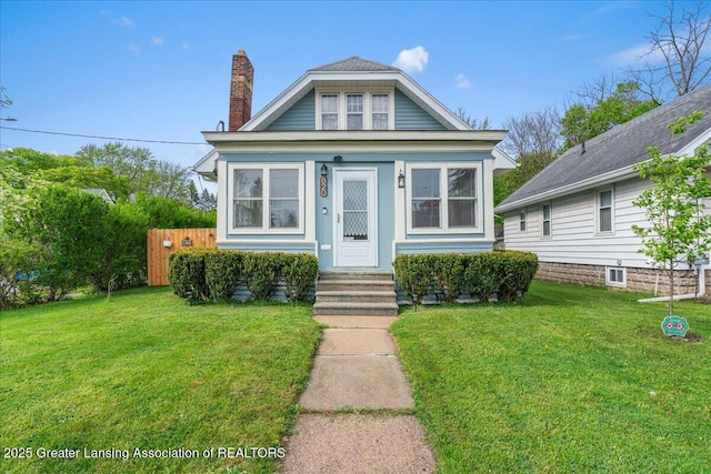 bungalow-style house featuring a chimney, fence, and a front yard