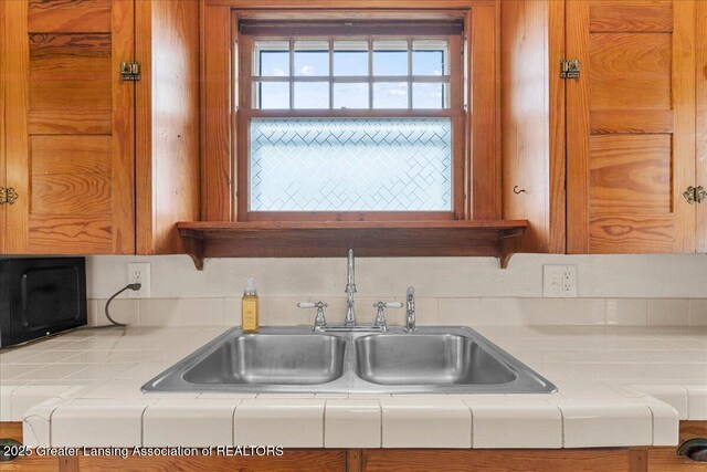kitchen with tile counters and a sink