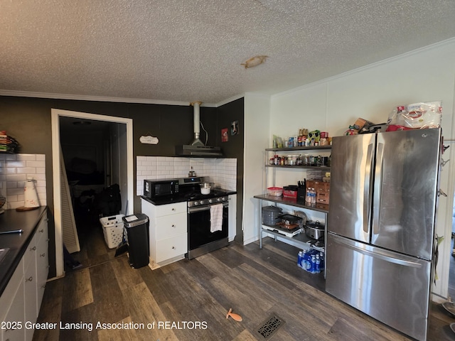 9304-9306 Parkhurst Hwy, Addison, MI 49220 - kitchen featuring crown molding, dark countertops, dark wood-type flooring, appliances with stainless steel finishes, and backsplash