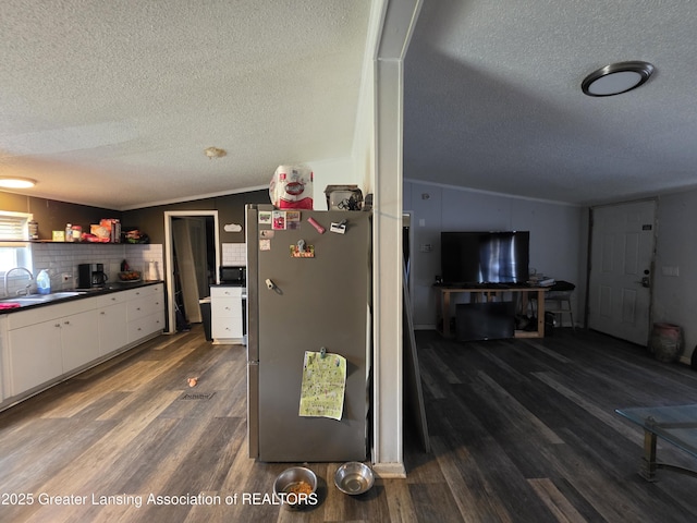 9304-9306 Parkhurst Hwy, Addison, MI 49220 - kitchen featuring a textured ceiling, wood finished floors, a sink, freestanding refrigerator, and white cabinetry