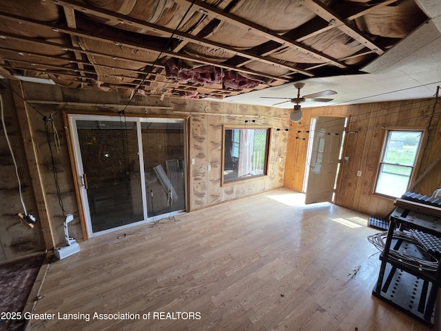 9304-9306 Parkhurst Hwy, Addison, MI 49220 - unfurnished living room featuring wood walls, wood finished floors, and a wealth of natural light