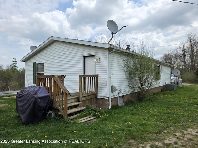9304-9306 Parkhurst Hwy, Addison, MI 49220 - rear view of house featuring a lawn, a wooden deck, and central AC
