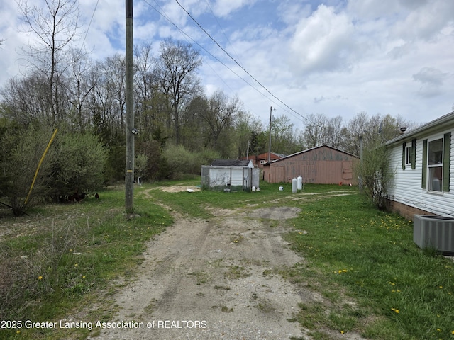 9304-9306 Parkhurst Hwy, Addison, MI 49220 - view of yard featuring an outbuilding, central AC unit, and driveway