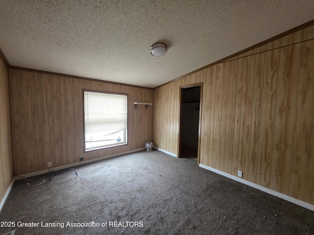 9304-9306 Parkhurst Hwy, Addison, MI 49220 - unfurnished room with a textured ceiling, wood walls, carpet floors, and ornamental molding