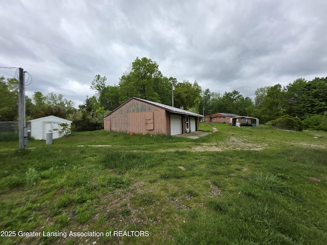 9304-9306 Parkhurst Hwy, Addison, MI 49220 - view of green lawn with a garage and an outdoor structure