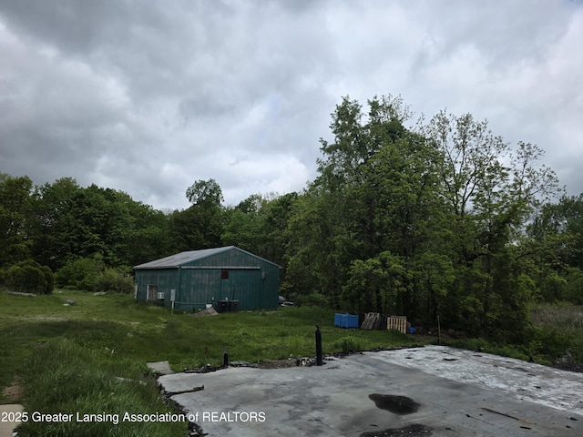 9304-9306 Parkhurst Hwy, Addison, MI 49220 - view of yard with a forest view, an outdoor structure, an outbuilding, and a garage