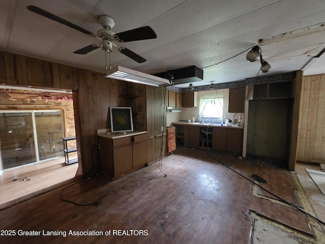 9304-9306 Parkhurst Hwy, Addison, MI 49220 - kitchen featuring wooden walls, brown cabinetry, wood finished floors, light countertops, and a ceiling fan