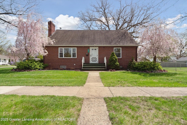 view of front of property featuring fence, a chimney, a front lawn, and brick siding