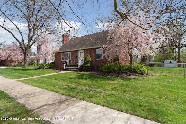 view of front of property with brick siding, fence, a chimney, and a front yard