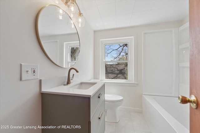 bathroom with tile patterned flooring, vanity, toilet, a washtub, and baseboards