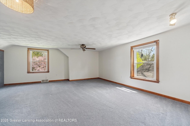 additional living space with visible vents, carpet, ceiling fan, and baseboards