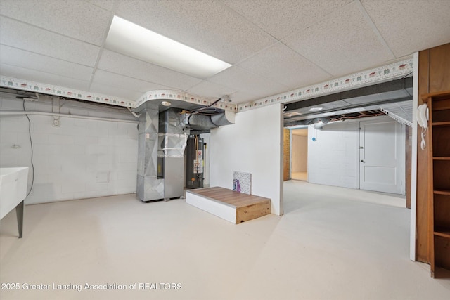 finished basement featuring water heater, heating unit, and a drop ceiling