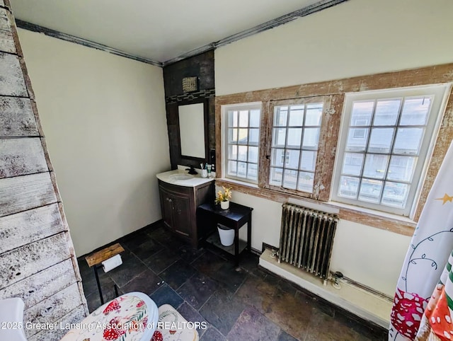 full bath with radiator heating unit, vanity, and stone tile floors
