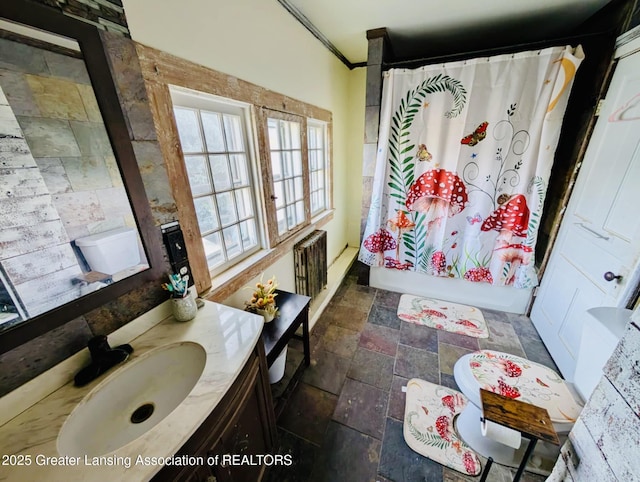 full bathroom with vanity, shower / tub combo with curtain, radiator, and stone finish floor