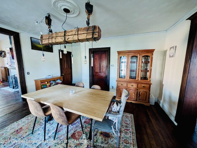dining space featuring baseboards, ornamental molding, and dark wood-type flooring