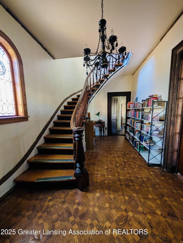 stairs featuring a notable chandelier