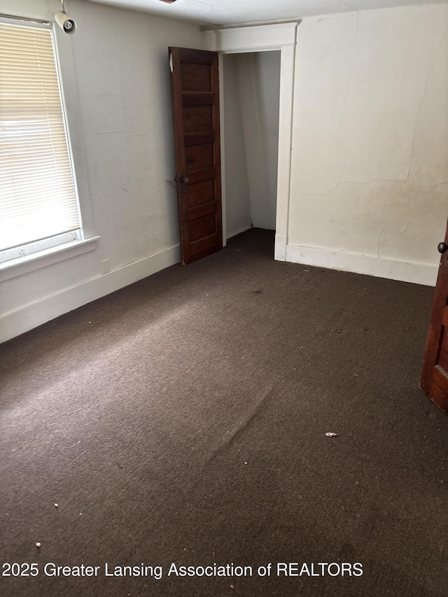 empty room with baseboards and carpet