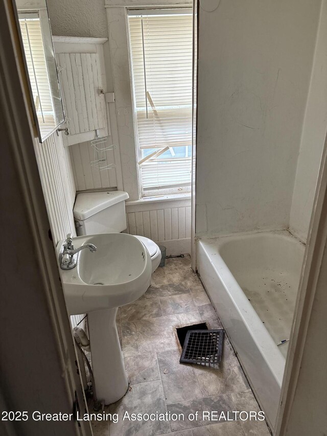 bathroom with a tub and toilet