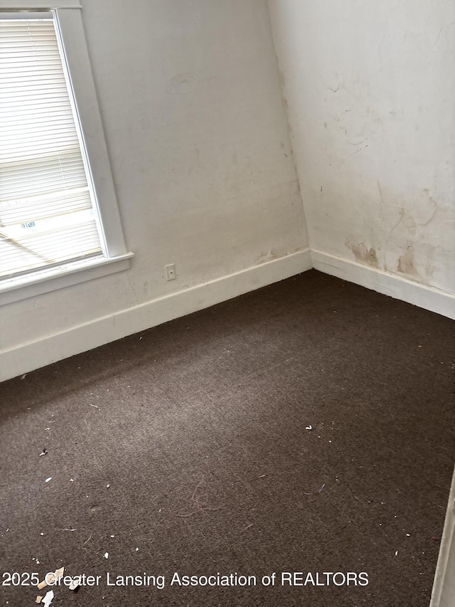 carpeted empty room featuring baseboards