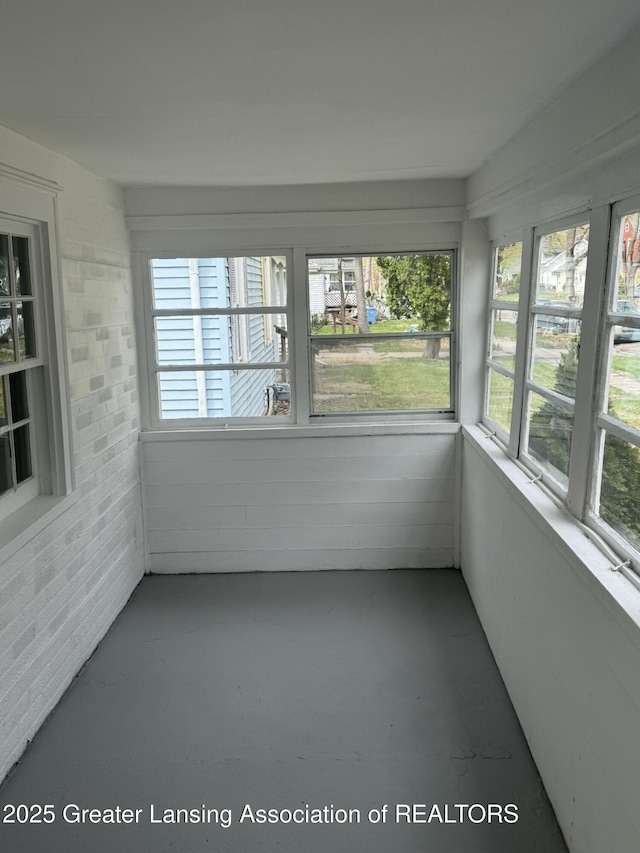unfurnished sunroom featuring finished concrete flooring