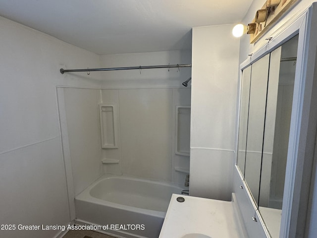bathroom featuring washtub / shower combination and vanity