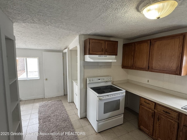 kitchen featuring under cabinet range hood, a textured ceiling, light tile patterned floors, and electric stove