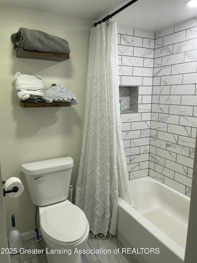 full bath with toilet, baseboards, and shower / bath combination with curtain