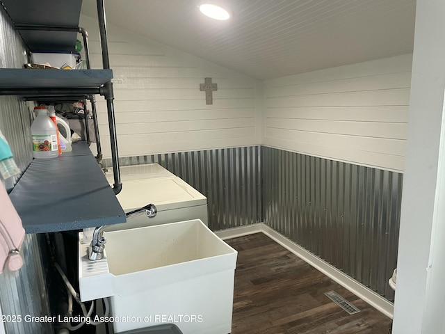 clothes washing area featuring laundry area, dark wood-style flooring, visible vents, a sink, and washer / dryer