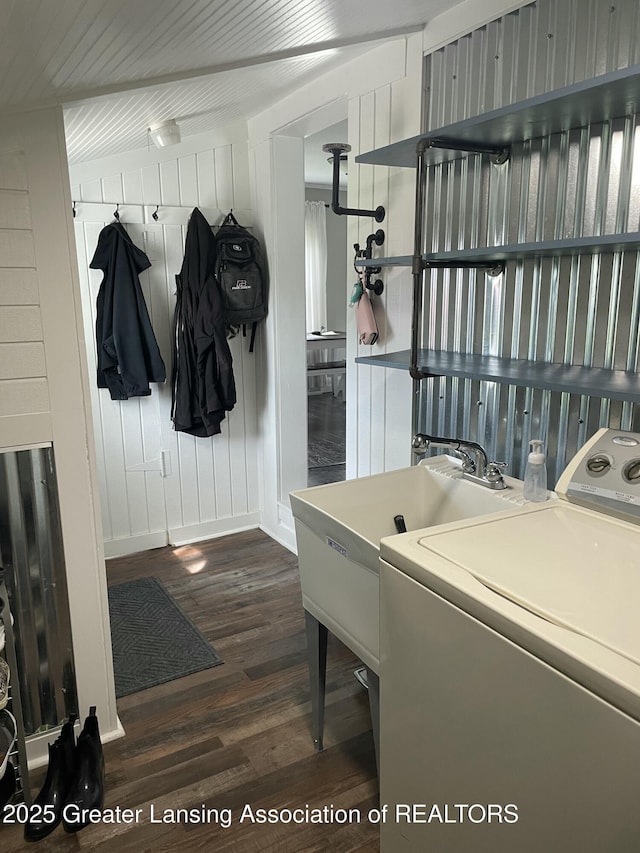washroom featuring laundry area, a sink, washer / dryer, and dark wood-type flooring