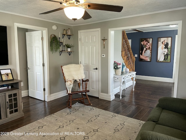 living area with wood finished floors, baseboards, stairway, a textured ceiling, and a ceiling fan