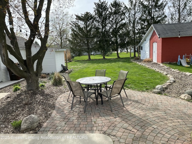 view of patio with an outdoor structure, a storage shed, and outdoor dining area