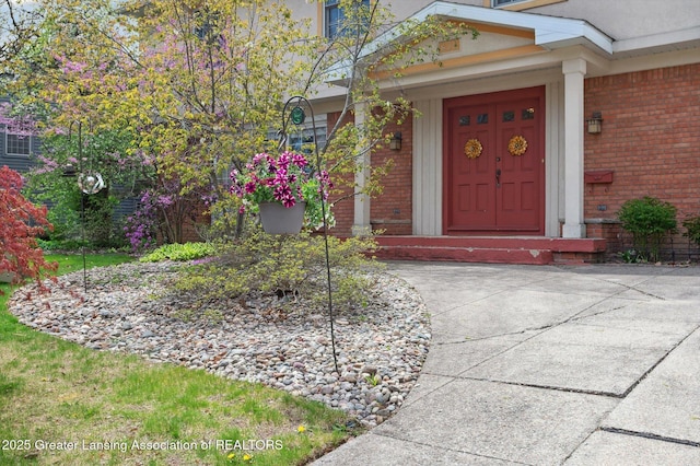 doorway to property featuring brick siding