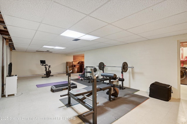workout area with tile patterned floors, washer / clothes dryer, and a drop ceiling