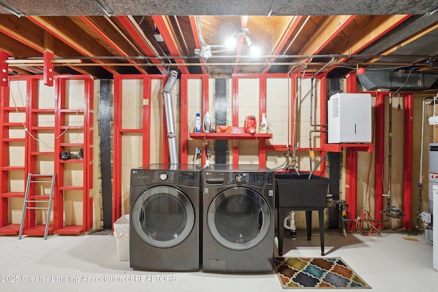 washroom with laundry area, a sink, and washing machine and dryer