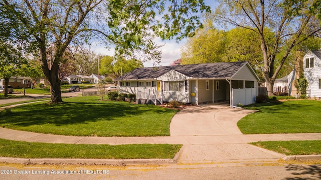 single story home with fence, driveway, a front yard, and an attached carport