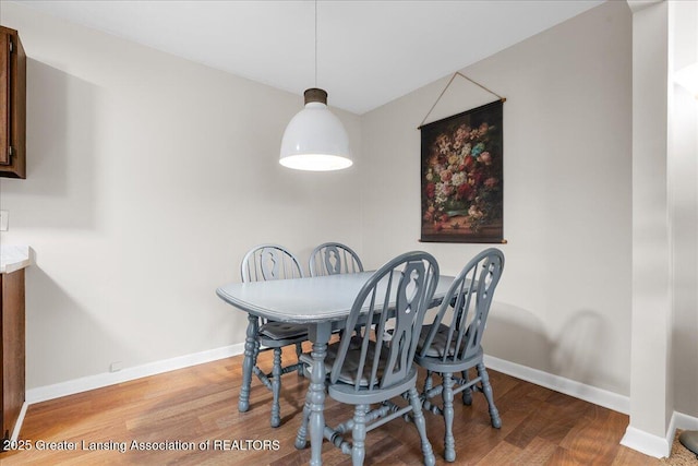 dining space featuring baseboards and wood finished floors