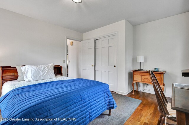 bedroom featuring baseboards, wood finished floors, and a closet