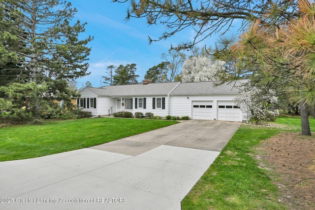 ranch-style home featuring concrete driveway, an attached garage, a chimney, and a front yard